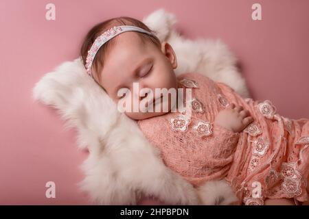 Neugeborenes Baby liegt und schläft auf einer weißen Felldecke. Liebe Stockfoto