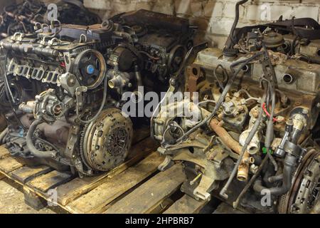 Paletten mit gebrauchten Motoren im Lager einer Organisation, die sich mit der Demontage von alten Autos und dem Verkauf von Gebrauchtwagenteilen beschäftigt. Stockfoto