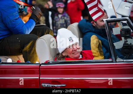 Richmond, USA. Barbara Ann Cochran, 1972 Olympiasiegerin im Slalom in Sapporo, fährt auf dem Beifahrersitz, rechts, als ihr Sohn Ryan Cochran-Siegle, der Silbermedaillengewinnerin im alpinen Ski-Super-G bei den Olympischen Spielen in Peking, nach Richmond, VT, begrüßt wird (Bevölkerung ca. 4.000) Am Samstag, den 19. Februar 2022, jubelte Richmond über seine Rückkehr aus China nach Vermont, VT, USA. Die Familie Cochran führte jahrzehntelang ein kleines lokales alpines Skigebiet in Richmond, wo Ryan zum ersten Mal Ski fuhr. Es ist jetzt eine gemeinnützige Organisation. Kredit: John Lazenby/Alamy Live Nachrichten Stockfoto