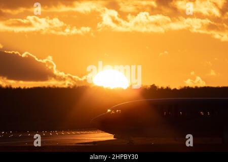 Flugzeug auf Taxifahrt, startbereit am Flughafen Stuttgart, gegen den goldenen Sonnenuntergang am Himmel mit einigen Wolken Stockfoto