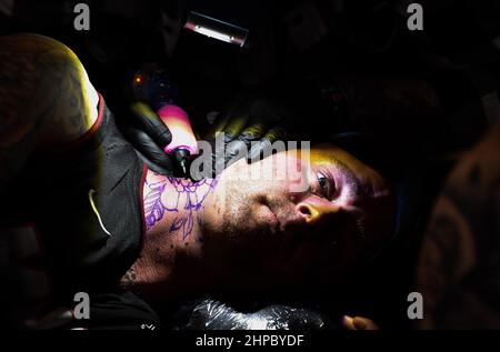 Brighton , UK 20th February 2022 - Tattooisten bei der Arbeit an der jährlichen Brighton Tattoo Convention 13th, an der über 350 Künstler an diesem Wochenende teilgenommen haben : Credit Simon Dack / Alamy Live News Stockfoto