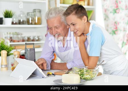 Älterer Mann mit Enkel Vorbereitung Abendessen in der Küche Stockfoto