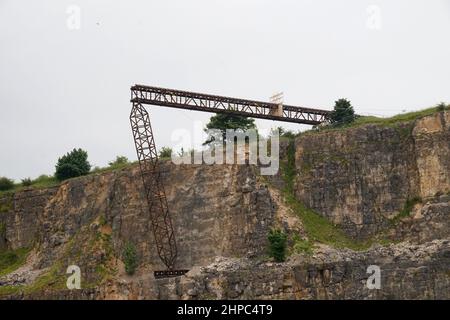 Eine gefälschte Eisenbahnbrücke, die über einem stillgelegten Steinbruch im Peak District, Großbritannien, für einen Stunt mit einem Zugunfall für den Film Mission Impossible 7 gebaut wurde. Stockfoto