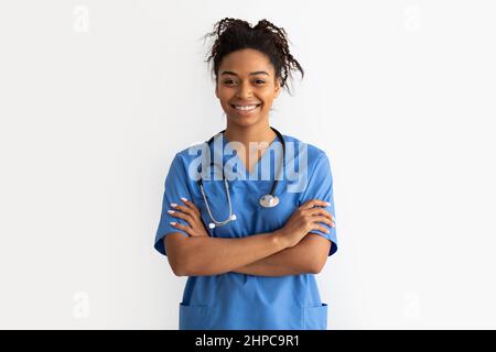 Porträt eines schwarzen Arztes, der mit gefalteten Armen auf die Kamera schaut Stockfoto