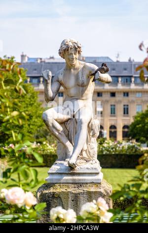 Eine Taube sitzt auf dem Arm der Statue des Schlangenbeschwörers im Garten des Palais-Royal in Paris, Frankreich. Stockfoto