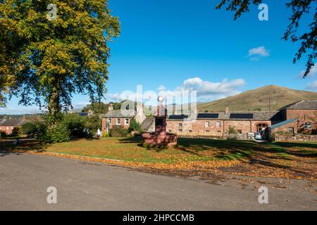 Dufton Fountain auf dem Dorfgrün mit Great Dun fiel im Hintergrund, Eden Valley, Cumbria, England, Großbritannien Stockfoto