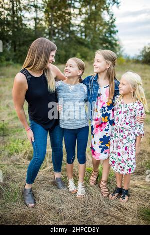 Mutter lächelte und sah ihre drei bueatiful Töchter an. Stockfoto