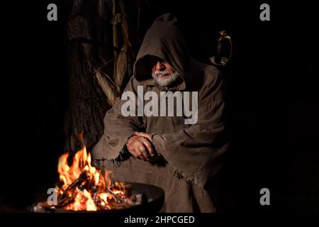 Ein armer Krieger aus dem Mittelalter am Lagerfeuer Stockfoto