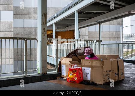 Hongkong, Hongkong. 20th. Februar 2022. Ein ausländischer Hausangestellter in ihrem provisorischen Tierheim verbringt sie einen Tag pro Woche in Admiralität. Angesichts der steigenden Anzahl von COVID-19-Fällen und einer Warnung des Chefs vor der Einhaltung der sozialen Distanzierungsregeln waren viele ausländische Arbeitnehmer vorsichtig, ihre Gruppen auf zwei zu beschränken, da sie sich vor Kälte und Regen schützten. Kredit: SOPA Images Limited/Alamy Live Nachrichten Stockfoto