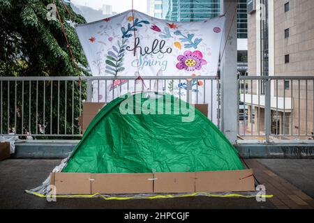 Hongkong, Hongkong. 20th. Februar 2022. Ausländische Hausangestellte versammeln sich in Admiralty zur Erholung und Erholung an ihrem einen freien Tag pro Woche. Angesichts der steigenden Anzahl von COVID-19-Fällen und einer Warnung des Chefs vor der Einhaltung der sozialen Distanzierungsregeln waren viele ausländische Arbeitnehmer vorsichtig, ihre Gruppen auf zwei zu beschränken, da sie sich vor Kälte und Regen schützten. Kredit: SOPA Images Limited/Alamy Live Nachrichten Stockfoto