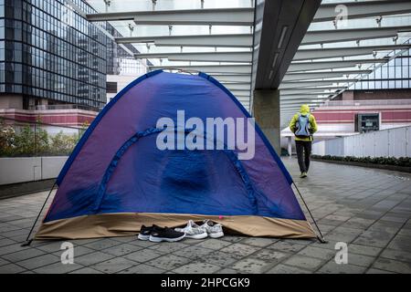 Hongkong, Hongkong. 20th. Februar 2022. Ausländische Hausangestellte versammeln sich in Admiralty zur Erholung und Erholung an ihrem einen freien Tag pro Woche. Angesichts der steigenden Anzahl von COVID-19-Fällen und einer Warnung des Chefs vor der Einhaltung der sozialen Distanzierungsregeln waren viele ausländische Arbeitnehmer vorsichtig, ihre Gruppen auf zwei zu beschränken, da sie sich vor Kälte und Regen schützten. Kredit: SOPA Images Limited/Alamy Live Nachrichten Stockfoto