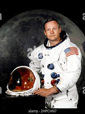 Offizielles NASA-Porträt des Astronauten Neil A. Armstrong, Kommandeur der Apollo 11 Lunar Landing-Mission in seinem Weltraumanzug, mit seinem Helm auf dem Tisch vor ihm. Hinter ihm ist ein großes Foto der Mondoberfläche. Das Foto wurde am 1. Juli 1969 aufgenommen; Apollo 11 startete am 16. Juli und war der Weltraumflug, bei dem die Menschen zum ersten Mal auf dem Mond landeten.