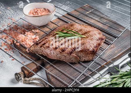 Flank Steak BBQ auf einem Grill mit Rosmarin. Weißer Hintergrund. Draufsicht Stockfoto