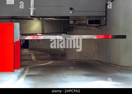 Eingang zum Parkplatz. Barriere in einer Tiefgarage. Parkplatz mit Schild und Details. Stockfoto