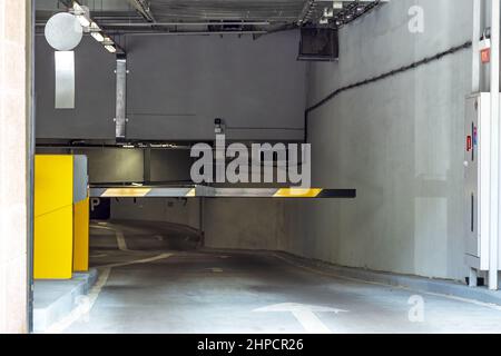 Eingang zum Parkplatz. Barriere in einer Tiefgarage. Parkplatz mit Schild und Details. Stockfoto