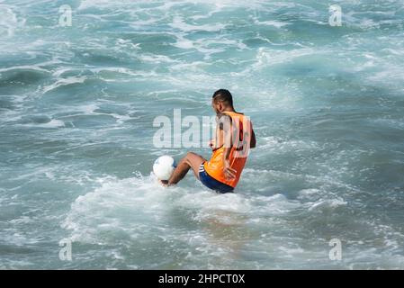 Salvador, Bahia, Brasilien - 15. August 2021: Menschen spielen Sandfußball am Strand von Farol da Barra in Salvador, Bahia, Brasilien. Stockfoto