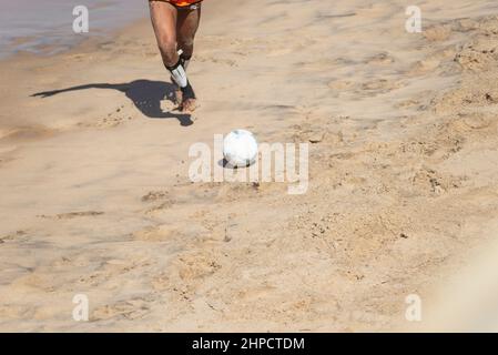 Salvador, Bahia, Brasilien - 15. August 2021: Menschen spielen Sandfußball am Strand Farol da Barra in Salvador, Bahia, Brasilien. Stockfoto