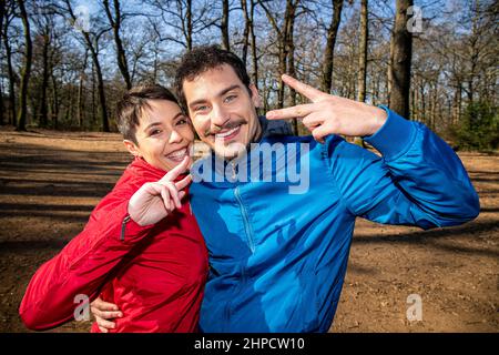 Das junge Paar macht ein Selfie im Wald. Porträt eines schönen lächelnden Paares auf einer Wanderung im Park. Stockfoto