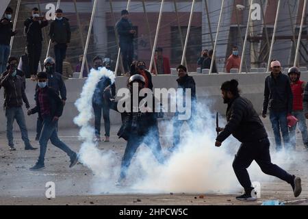 Kathmandu, Nepal, Nepal. 16th. Februar 2022. Ein Demonstranten schleudert während eines Protestes in Kathmandu ein Tränengas auf die Polizei zurück.verschiedene politische Parteien treffen sich mit Jugendflügeln vor dem Bundestag mit der nepalesischen Polizei, um gegen einen Zuschuss in Höhe von 500 Millionen US-Dollar zu protestieren, der als Millennium Challenge Corporation (MCC) Pakt bekannt ist. Das Abkommen, das 2017 unterzeichnet wurde, muss noch vom parlament ratifiziert werden, das dies bis Ende Februar 2022 tun muss. Die Demonstranten sagen, dass das Abkommen Nepals Souveränität untergräbt und den USA zu viel Einfluss überlässt. (Bild: © Prabin Ranabhat/SOPA Images via ZUMA Press Wire) Stockfoto