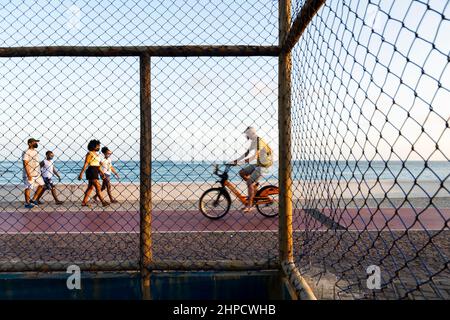 Menschen, die am Strand von Paciencia in Rio Vermelho in Salvador, Brasilien, entlang gehen. Stockfoto