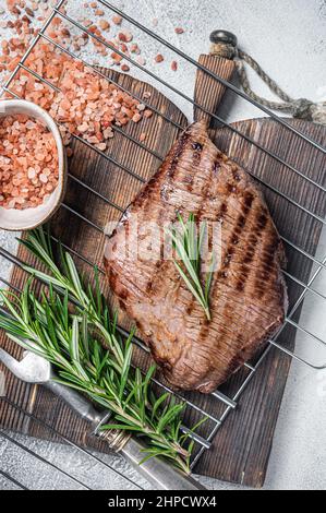 Flank Steak BBQ auf einem Grill mit Rosmarin. Weißer Hintergrund. Draufsicht Stockfoto