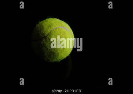 Grüner Tennisball auf schwarzem Hintergrund Stockfoto