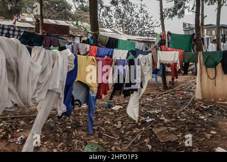 In den Slums von Kibera in Nairobi trocknen die Kleidungsstücke an Seilen. Im Kibera Slum, dem berüchtigten Zuhause, wo das Leben immer schwierig und herausfordernd zu sein scheint Stockfoto