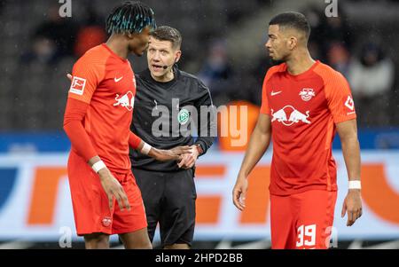 Berlin, Deutschland. 20th. Februar 2022. Fußball: Bundesliga, Hertha BSC - RB Leipzig, Matchday 23, Olympiastadion. Mohamed Simakan (l.) und Benjamin Henrichs (r.) von RB Leipzig sprechen mit Schiedsrichter Patrick Ittrich. Quelle: Andreas Gora/dpa - WICHTIGER HINWEIS: Gemäß den Anforderungen der DFL Deutsche Fußball Liga und des DFB Deutscher Fußball-Bund ist es untersagt, im Stadion und/oder vom Spiel aufgenommene Fotos in Form von Sequenzbildern und/oder videoähnlichen Fotoserien zu verwenden oder zu verwenden./dpa/Alamy Live News Stockfoto