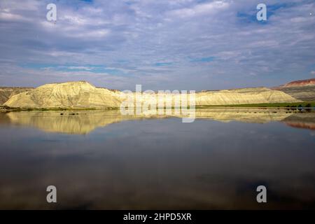 Blaue Wolken mit Spiegelung von bunten Bergen im See Stockfoto