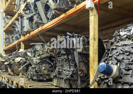 Paletten mit gebrauchten Motoren im Lager einer Organisation, die sich mit der Demontage von alten Autos und dem Verkauf von Gebrauchtwagenteilen beschäftigt. Stockfoto