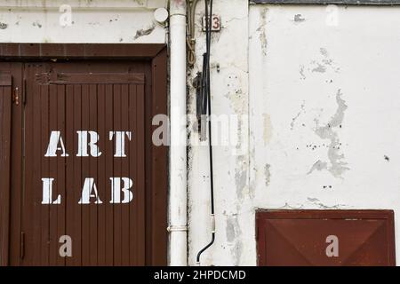 Außenansicht eines künstlerischen Labors mit dem Schild "Art Lab" auf der hölzernen Eingangstür eines alten Gebäudes, Sanremo, Imperia, Ligurien, Italien Stockfoto