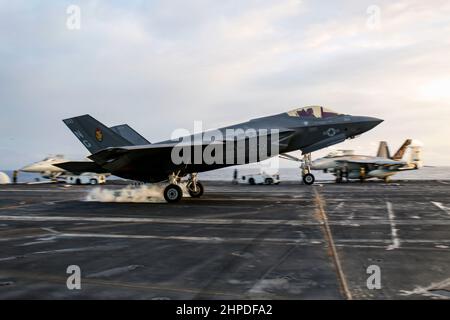 PHILIPPINISCHES MEER (Feb 19, 2022) eine F-35C Lightning II, die den 'Black Knights' of Marine Fighter Attack Squadron (VMFA) 314 zugewiesen wurde, landet auf dem Flugdeck des Nimitz-Klasse-Flugzeugträgers USS Abraham Lincoln (CVN 72). Die Abraham Lincoln Strike Group befindet sich im geplanten Einsatzgebiet der US-Flotte für 7th, um die Interoperabilität durch Allianzen und Partnerschaften zu verbessern und gleichzeitig als reaktionsfähige Truppe zur Unterstützung einer freien und offenen Region im Indo-Pazifik-Raum zu dienen. (USA Navy Foto von Mass Communication Specialist 3rd Klasse Michael Singley) Stockfoto