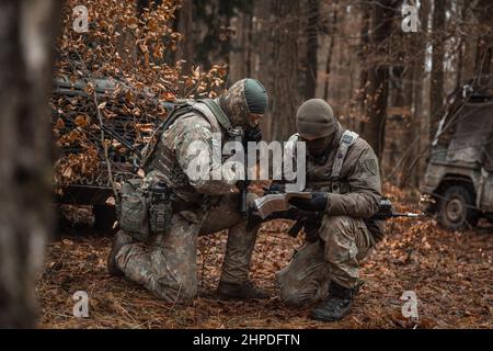 Litauische Soldaten lasen am 24. Januar 2022 während der Allied Spirit 22 im Trainingsgebiet Hohenfels in Deutschland eine Karte vor. Allied Spirit 22 (AS22) ist eine US Army Europe-Africa (USAREUR-AF) geleitete, 7th Army Training Command (7ATC) geleitete, Joint Multinary Readiness Center (JMRC) moderierte Trainingsübung für die Lettische 1st Mechanized Infantry Brigade (LVA MI BDE) vom 11. Januar 22 bis 05. Februar 22. Die Übung wird die Interoperabilität und Bereitschaft der NATO und wichtiger Partner in allen spezifischen Kriegskampffunktionen entwickeln und verbessern. Stockfoto