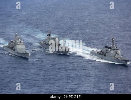 PHILIPPINISCHES MEER (Feb 20, 2022) Japan Maritime Self-Defense Force (JMSDF) Towada-Klasse Auffüllöler JS Towada (AOE 422), Mitte, Refuels Ticonderoga-Klasse Lenkraketen-Kreuzer USS Mobile Bay (CG 53), links, als JMSDF Lenkraketen-Zerstörer JS Myoko (DDG 175) wegsegelt. Die Abraham Lincoln Strike Group befindet sich im geplanten Einsatzgebiet der US-Flotte für 7th, um die Interoperabilität durch Allianzen und Partnerschaften zu verbessern und gleichzeitig als reaktionsfähige Truppe zur Unterstützung einer freien und offenen Region im Indo-Pazifik-Raum zu dienen. (USA Navy Foto von Mass Communication Specialist Seaman Aleksandr F. Stockfoto