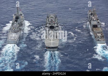 PHILIPPINISCHES MEER (Feb 20, 2022) Japan Maritime Self-Defence Force (JMSDF) Towada-Klasse Nachschuböler JS Towada (AOE 422), Mitte, Refuels Ticonderoga-Klasse Lenkraketen-Kreuzer USS Mobile Bay (CG 53), links, und JMSDF Lenkraketen-Zerstörer JS Myoko (DDG 175). Die Abraham Lincoln Strike Group befindet sich im geplanten Einsatzgebiet der US-Flotte für 7th, um die Interoperabilität durch Allianzen und Partnerschaften zu verbessern und gleichzeitig als reaktionsfähige Truppe zur Unterstützung einer freien und offenen Region im Indo-Pazifik-Raum zu dienen. (USA Navy Foto von Mass Communication Specialist Seaman Aleksandr Freutel) Stockfoto