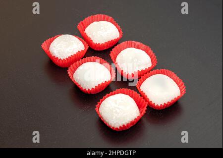 6 Stück Rote Bean Mochi im japanischen Stil in Pappbechern auf einem dunklen Tisch Stockfoto