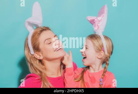 Glückliche Mutter und Kind Tochter Ostern feiern. Nettes kleines Mädchen mit lustigen Gesicht in Hasen Ohren lachen, lächeln und Spaß haben. Stockfoto