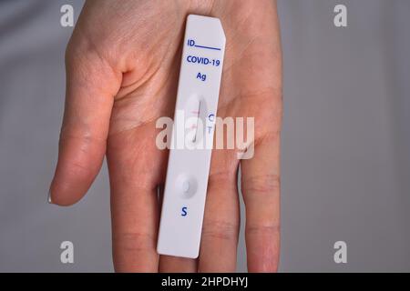 Frau hält einen schnellen Covid-Antigen-Test oder einen exprimieren Covid-Test mit positivem Covid-19-Ergebnis Stockfoto