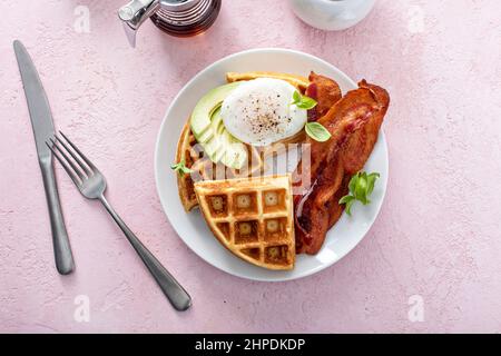 Knusprige belgische Waffeln mit Avocado und Speck zum Frühstück Stockfoto