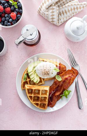 Knusprige belgische Waffeln mit Avocado und Speck zum Frühstück Stockfoto