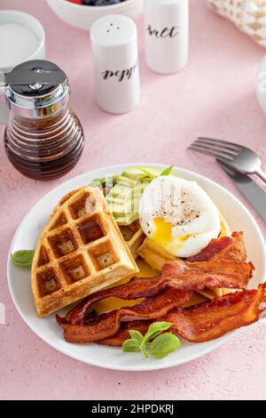 Knusprige belgische Waffeln mit Avocado und Speck zum Frühstück Stockfoto