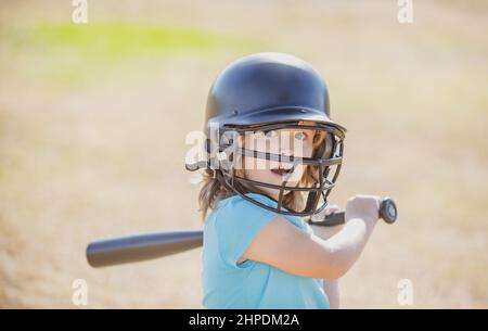 Der kleine blonde Junge mit Gesichtsausdruck hält einen Baseballschläger. Stockfoto