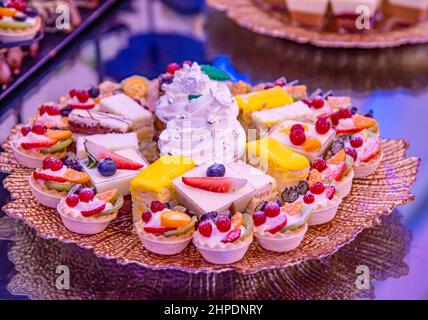 Verschiedene Cupcakes auf einem braunen Teller Stockfoto