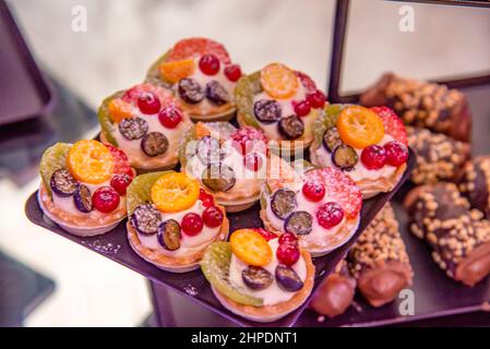 Verschiedene Cupcakes auf einem braunen Teller Stockfoto