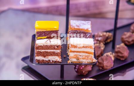 Verschiedene Cupcakes auf einem schwarzen Teller Stockfoto