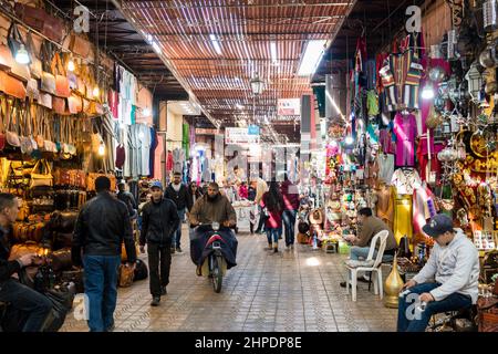 Touristen und Einheimische navigieren durch die belebten Fußgängerwege in der Medina, Marrakesch und Marokko Stockfoto