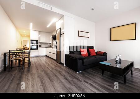 Verbundenes Wohnzimmer mit Esstisch und Küche in der Ferienwohnung Studio Stockfoto