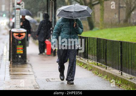 London, Großbritannien. 19th. Februar 2022. Bei Niederschlägen in London untersteht ein Mann unter einem Regenschirm. (Foto: Dinendra Haria/SOPA Images/Sipa USA) Quelle: SIPA USA/Alamy Live News Stockfoto