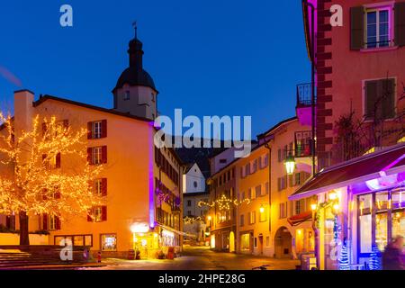 Beleuchtete Brig Straßen während der Winterweihnachtszeit bei Nacht, Schweiz Stockfoto