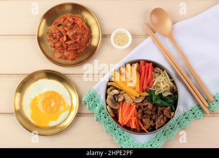 Bibimbap, gemischter Reis mit Fleisch und verschiedenen Gemüsesorten, koreanische Küche mit Kimchi. Draufsicht Stockfoto